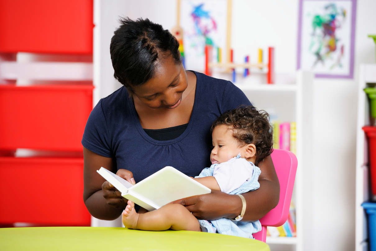 Carer/ Childminder/Teacher Reading With A Young Baby